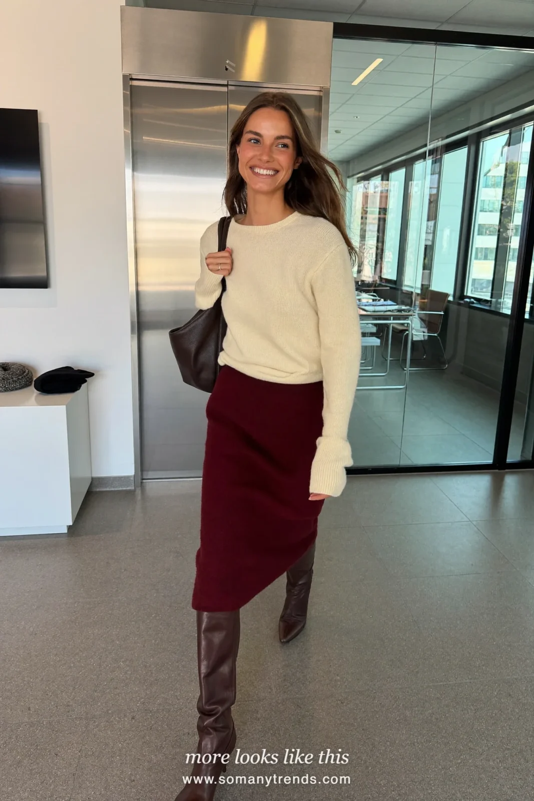 Woman in a cream fine knit sweater, burgundy midi skirt and chocolate brown knee-high boots, first day at work outfit 11