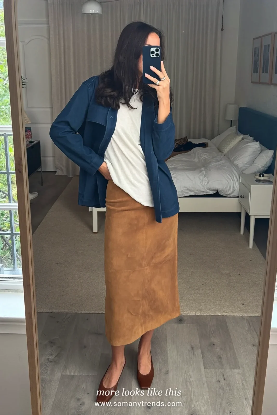 Woman in an ivory tee, ink blue boxy jacket, camel suede midi skirt and brown ankle-height square-toe shoes, first day at work outfit 12