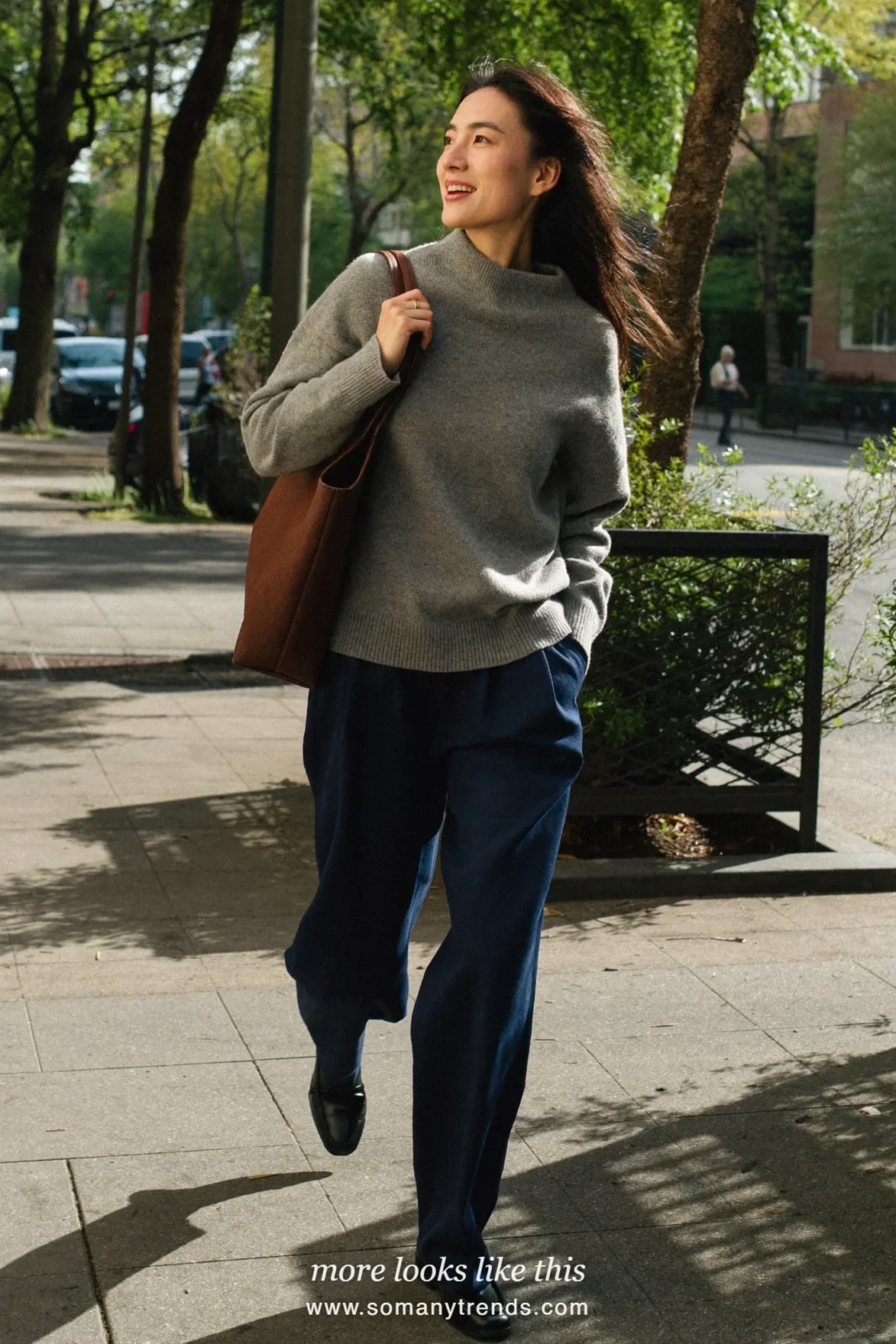 Woman in a soft gray fine knit sweater, ink blue wide-leg pants and black leather loafers, first day at work outfit 13