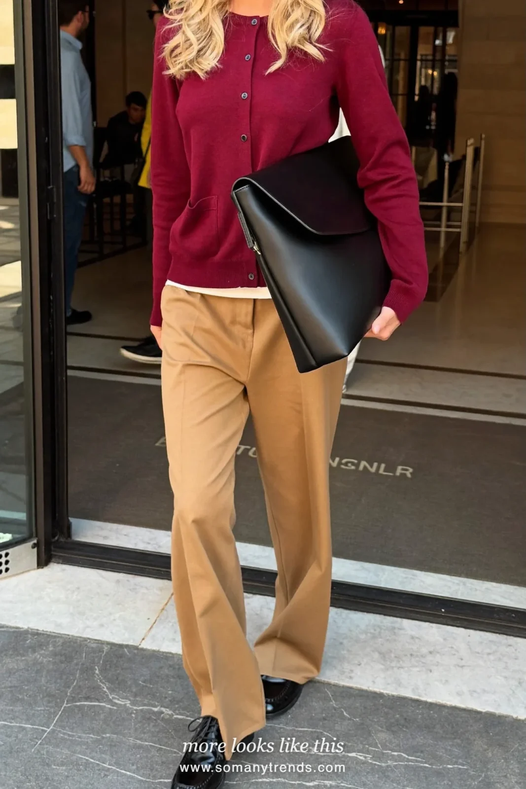 Woman in a burgundy fine knit cardigan, white tee, camel wide-leg pants and black leather derby shoes, first day at work outfit 14