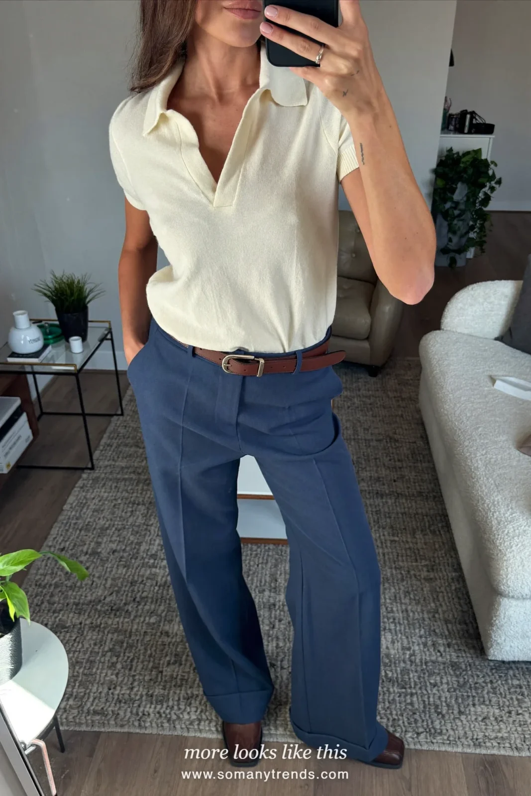 Woman in an ivory knit polo, ink blue tailored straight pants, brown leather belt and brown derby shoes, first day at work outfit 16