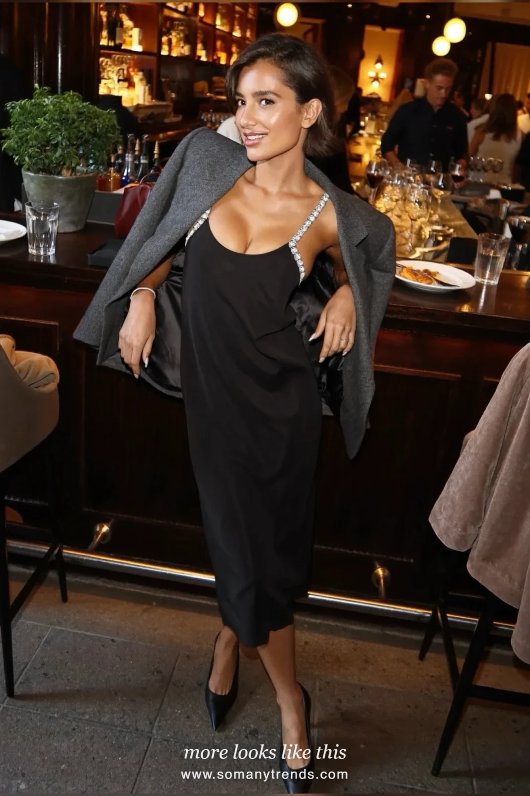 Woman in a black slip dress with crystal straps, oversized blazer, sheer tights and pointed pumps at a dinner, outfit 18