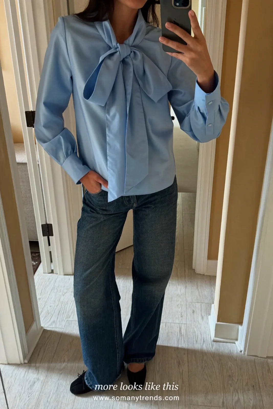 Woman in a baby blue bow blouse, dark blue wide-leg jeans and black ballet flats, outfit 8