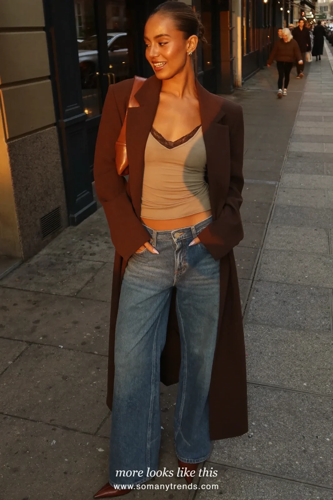 Woman in a sand lace-trim camisole, brown relaxed blazer, straight blue jeans and brown pointed boots, outfit 10