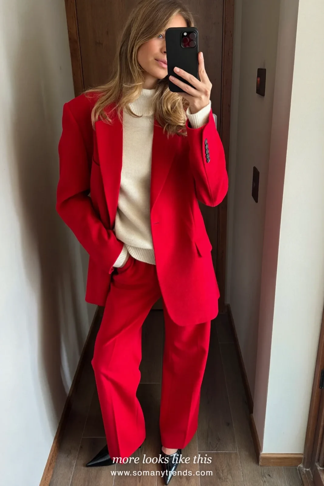 Woman in a red blazer and pants set, cream roll neck and black pumps at a holiday party, look 8