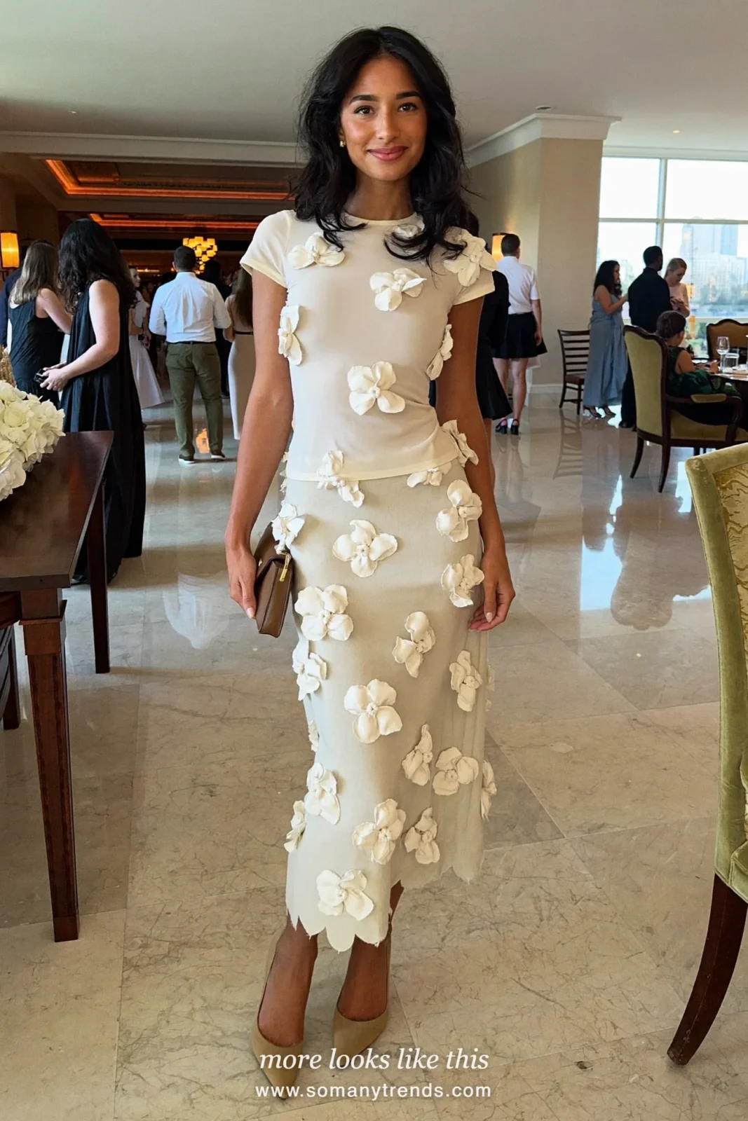 Woman in an ivory 3D floral matching top and skirt set with nude heels at a holiday party, look 14
