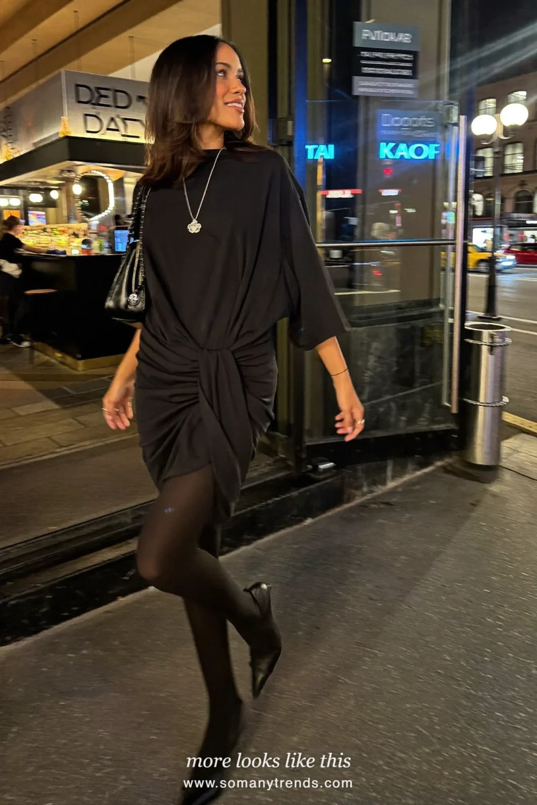 Woman in a draped black jersey dress with black pumps and a pendant necklace, party outfit 27
