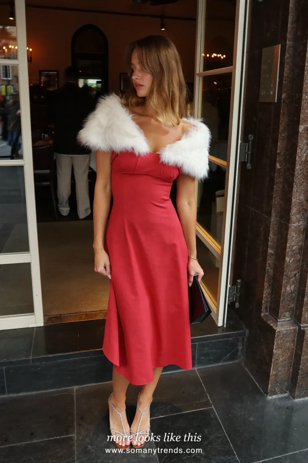 Woman in a red dress with white faux-fur trim and strappy heels with diamond studs at a Christmas Eve dinner, outfit 1