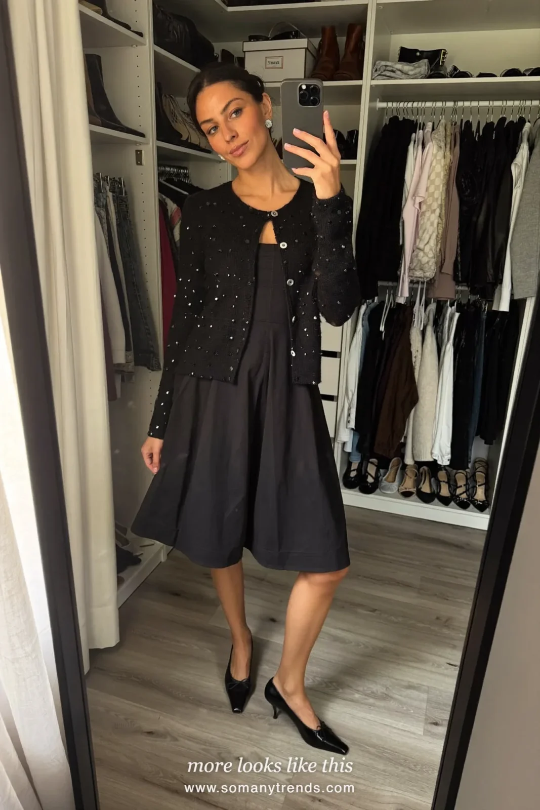 Woman in a rhinestone-button cardigan over a black dress and ballet flats at a family Christmas Eve dinner, outfit 24