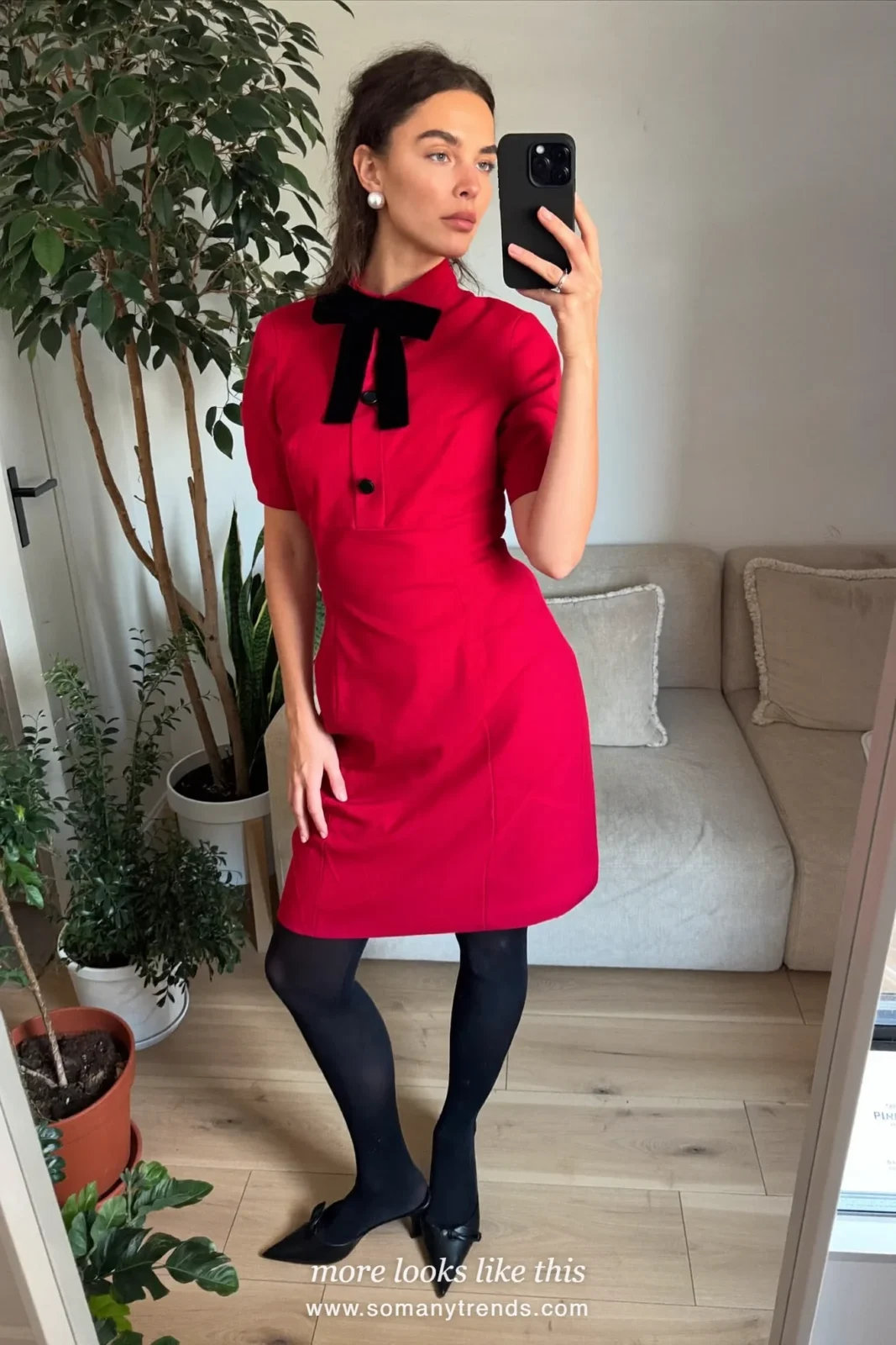 Woman in a red crepe dress with a velvet bow, black tights, pointed heels and pearl studs at a Christmas Eve dinner, outfit 28