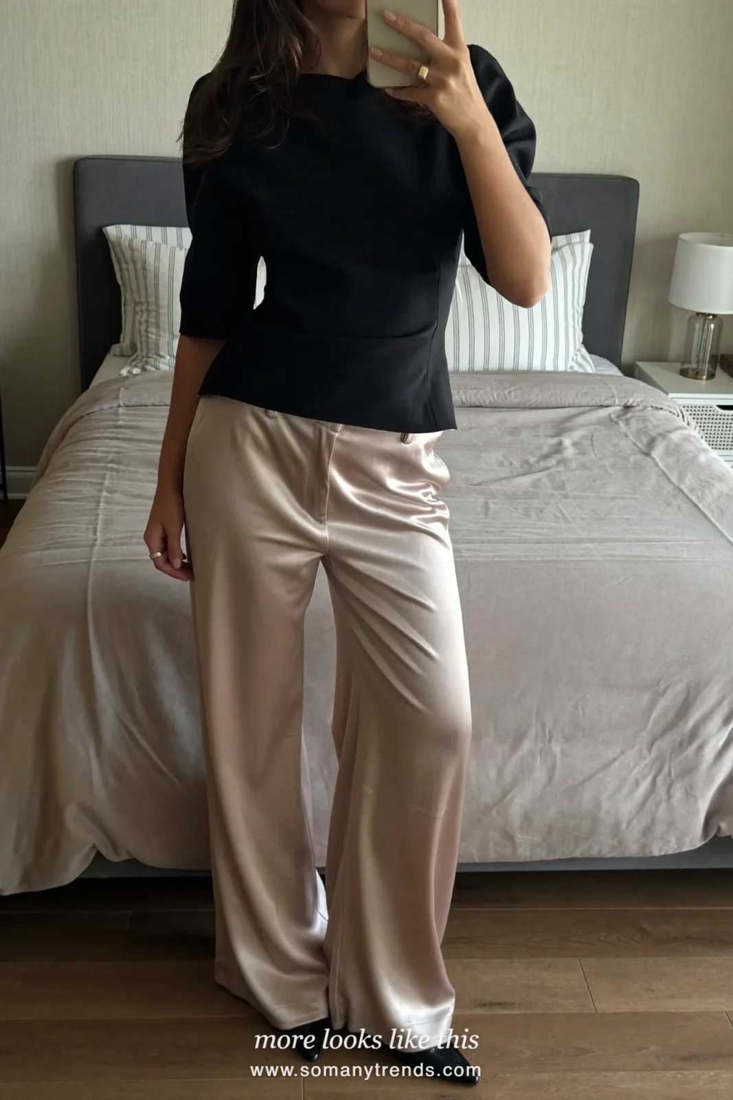 Woman in champagne satin wide-leg pants, black structured top and black heels at a holiday party, look 20