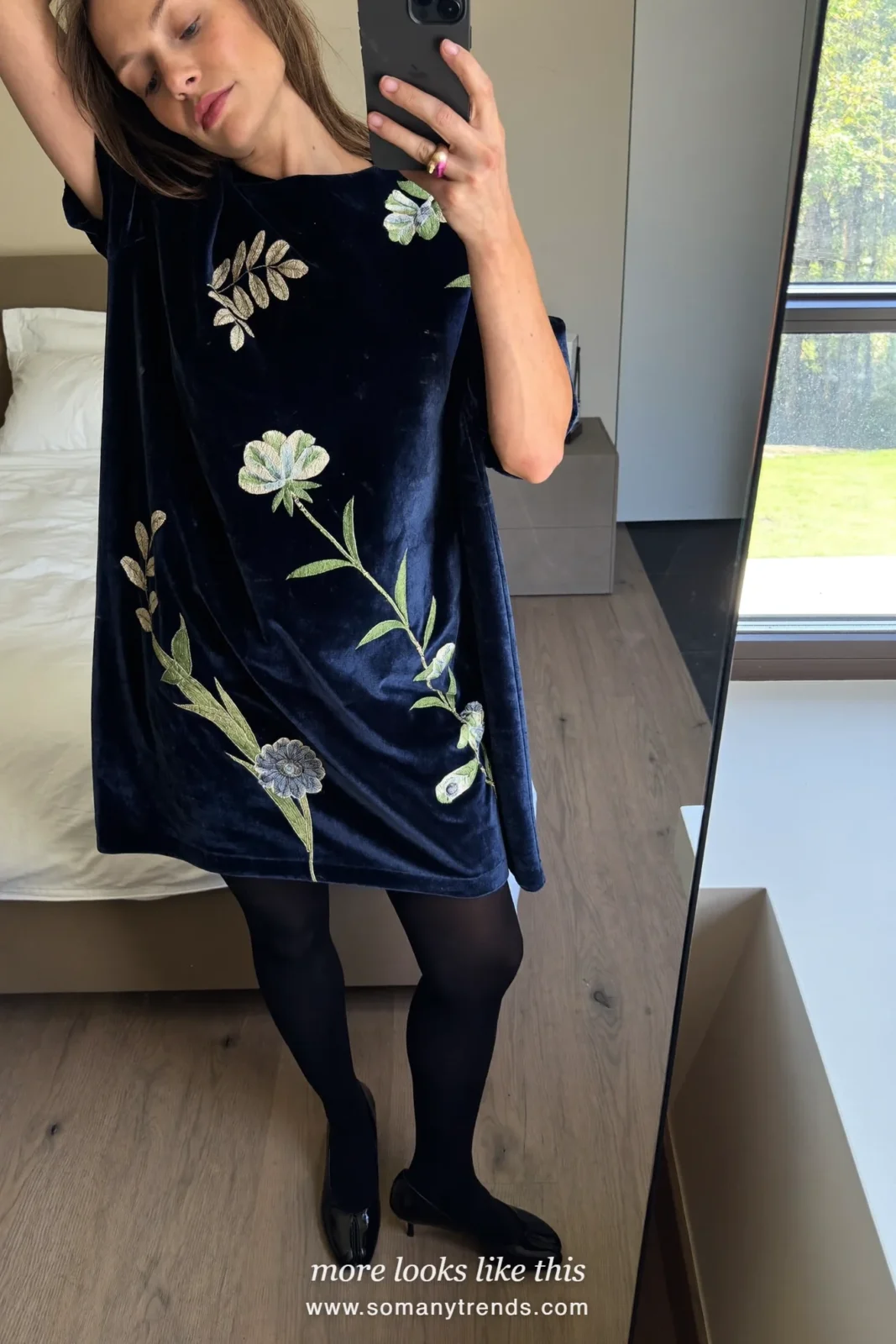 Woman in a navy velvet dress with floral appliques, sheer tights and black pumps, party outfit 20