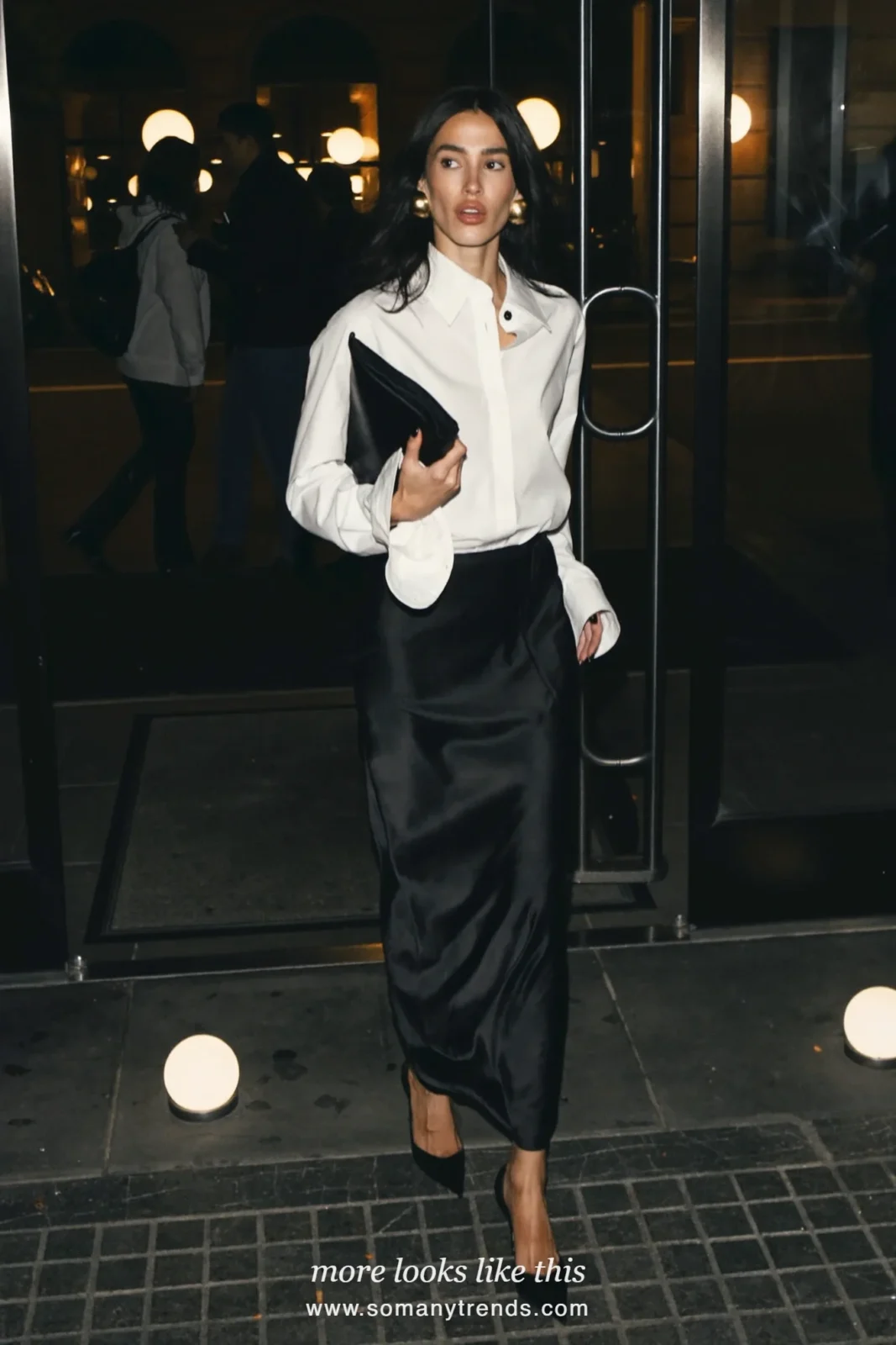 Woman in a crisp white shirt, long black satin skirt, black heels and a sleek clutch, party outfit 26
