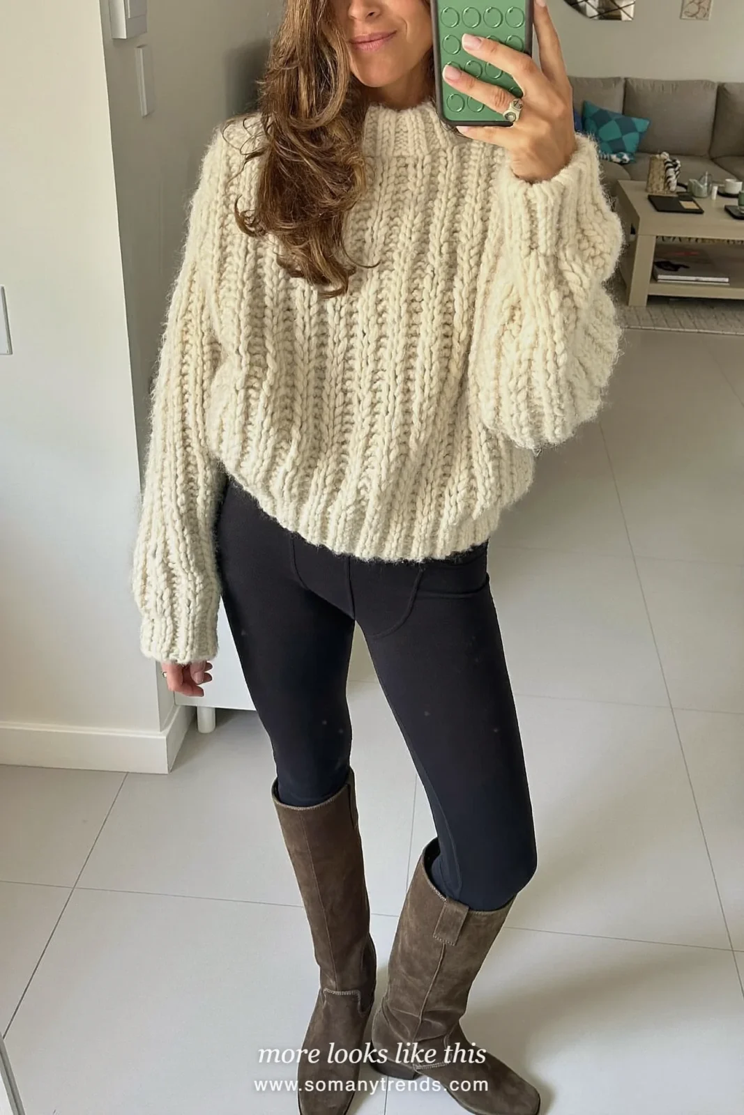 Woman in a cream knit sweater, black leggings, chocolate suede boots and a suede bag, look 16