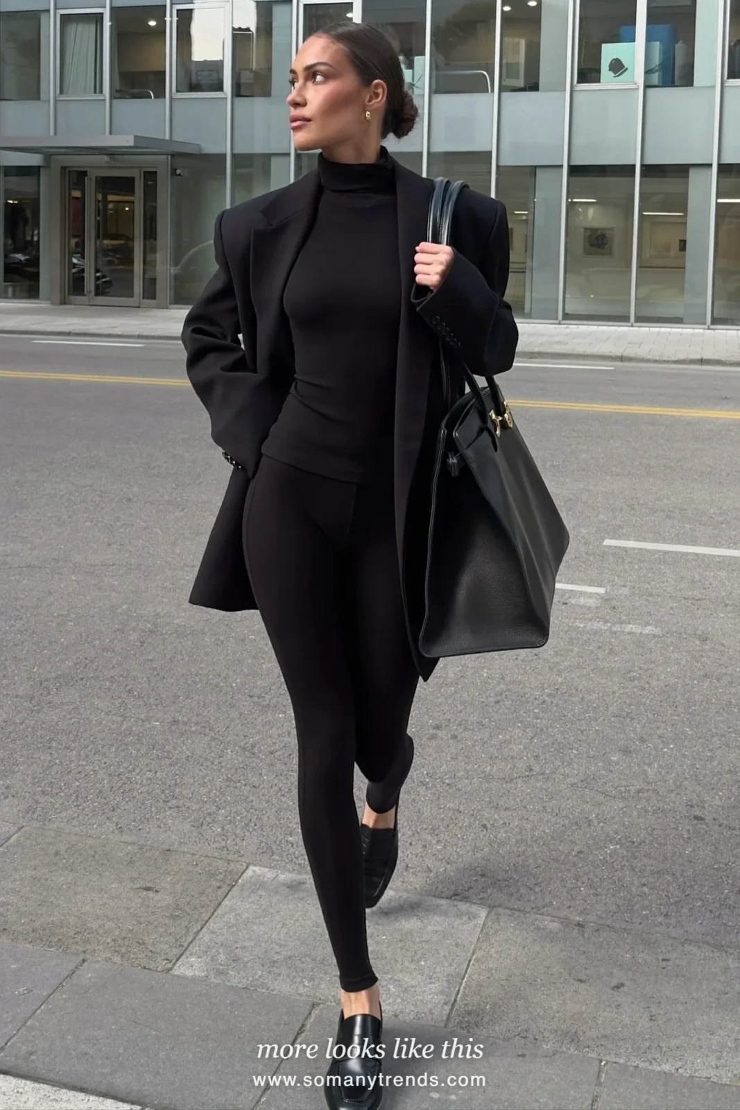 Woman in a long black blazer, turtleneck, black leggings and loafers with a structured tote, look 25