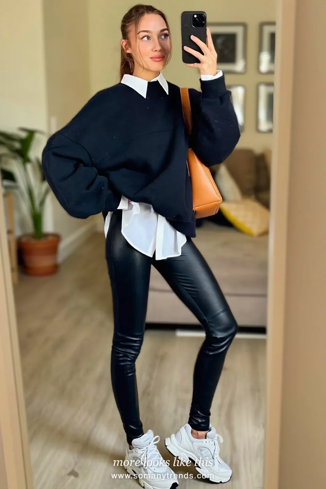 Black sweatshirt over white shirt, black faux leather leggings, tan bag and white sneakers, outfit 12