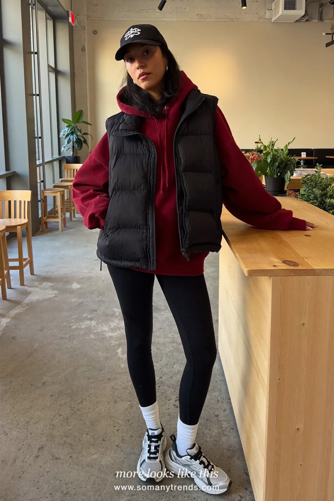 Burgundy hoodie, black puffer vest, black leggings, white socks, silver sneakers and cap, outfit 30