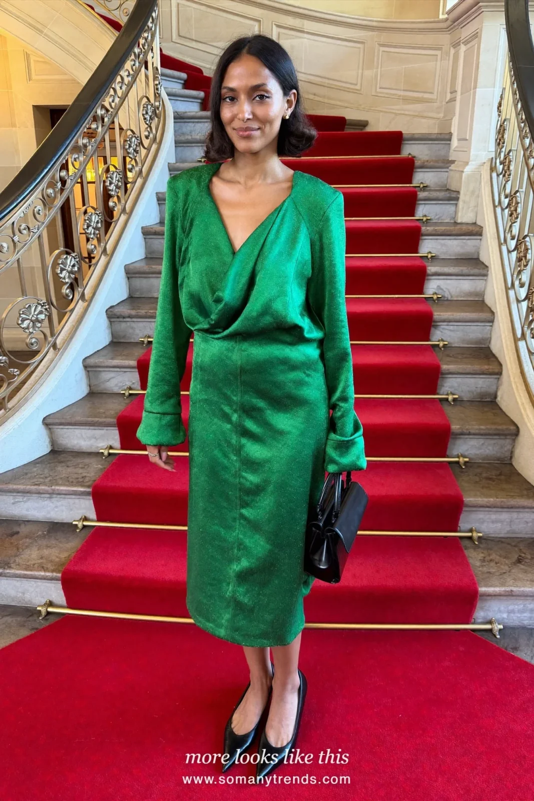 Woman in an emerald satin cowl-neck midi dress, black pumps and a small black bag, cocktail outfit 18