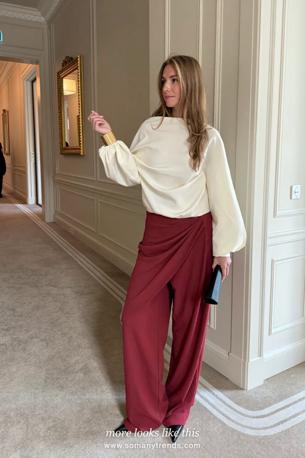 Woman in wide burgundy pants, cream blouse, pointed pumps and a gold cuff, cocktail outfit 9