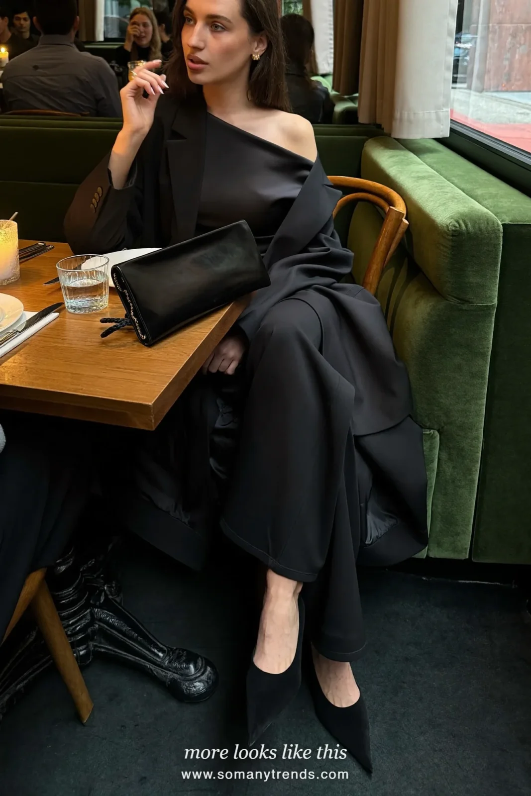 Woman in a black satin one-shoulder top, wide black pants and an oversized black blazer, cocktail outfit 11
