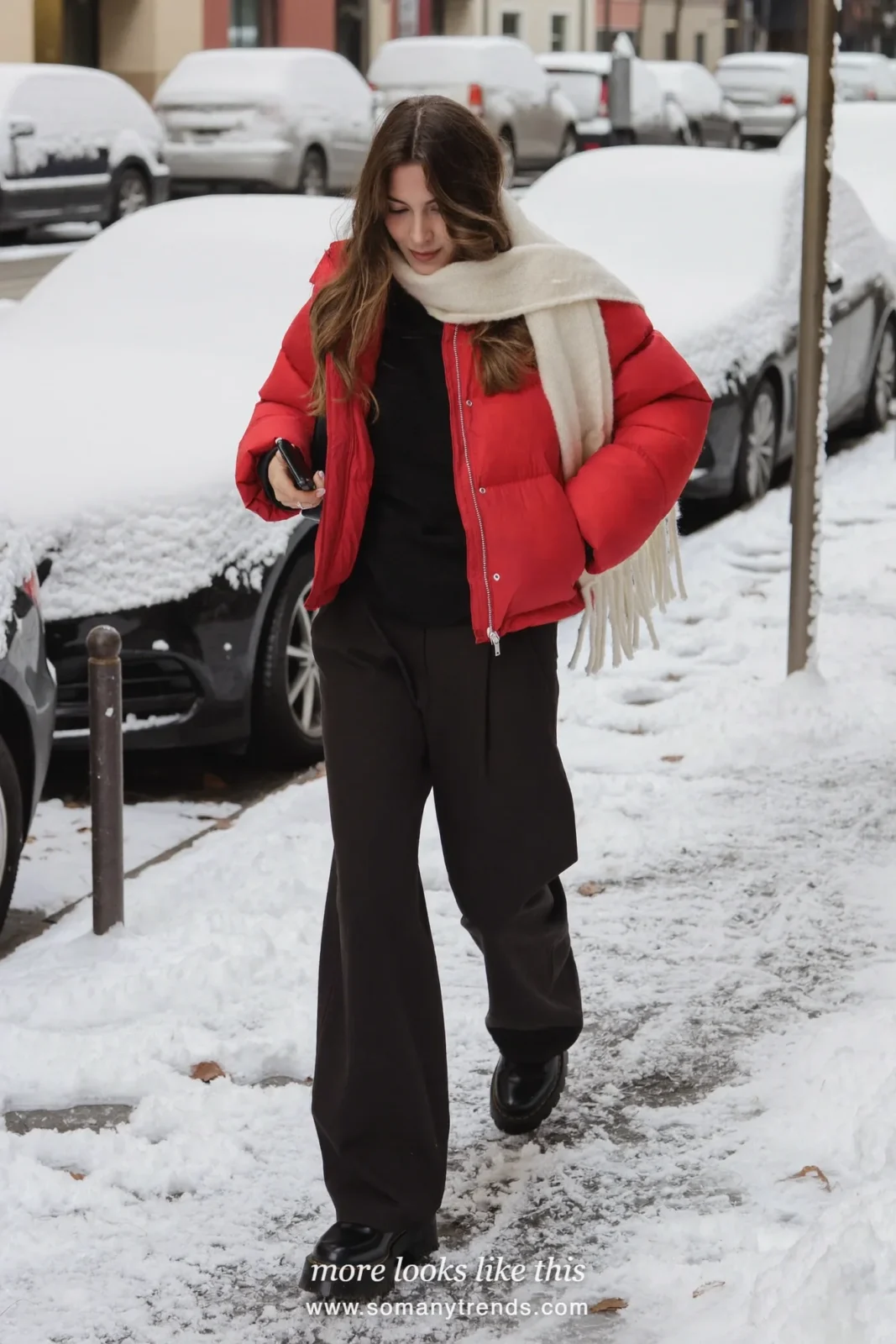 Red puffer jacket with black pants, ivory scarf and black boots on a snowy street, outfit 7