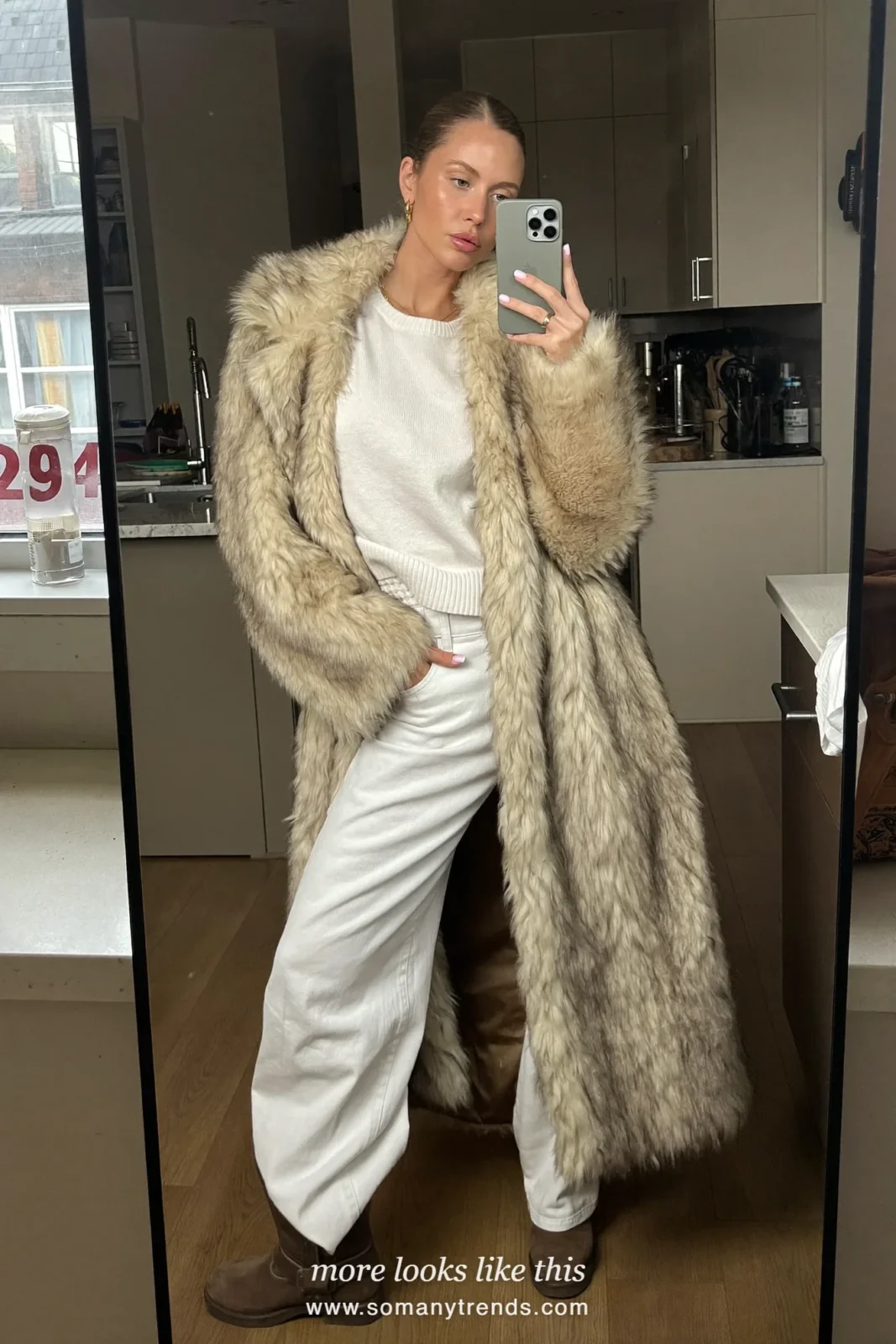 Beige faux-fur coat with white knit, white jeans, brown boots and dark bag on a snowy street, outfit 20