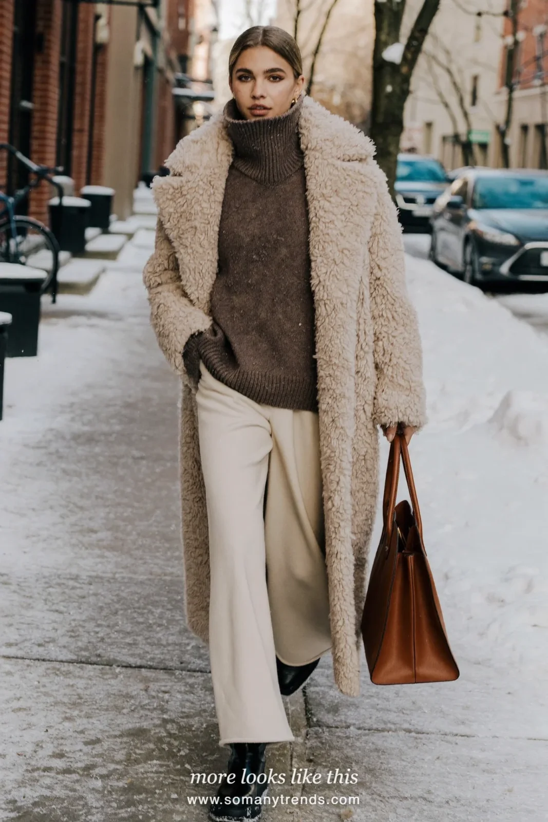 Oatmeal teddy coat with dark knit, wide cream pants and black boots on a snowy street, outfit 22