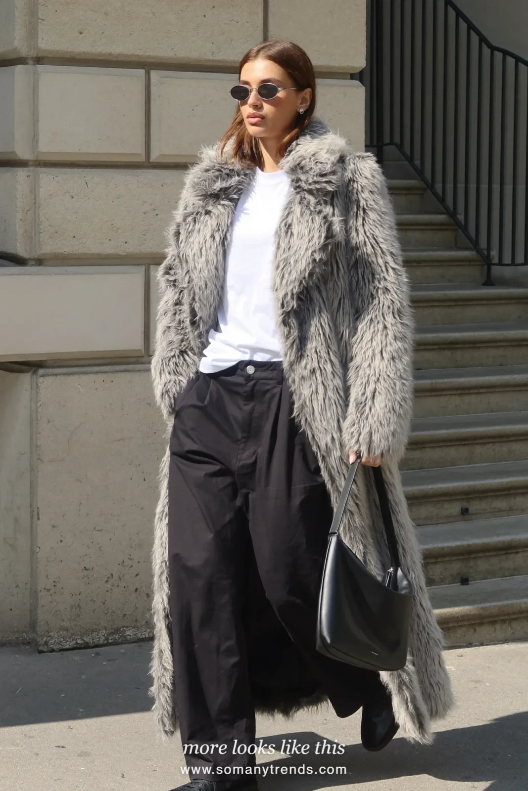 Long gray shaggy faux fur coat over a white tee, black wide pants, oval sunglasses and a black bag, outfit 5