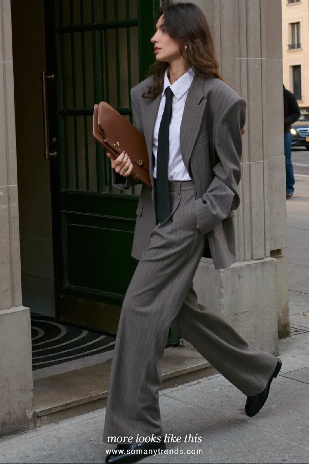 Woman in gray pinstripe oversized blazer, matching wide-leg pants, white shirt, skinny black tie and black loafers, look 1