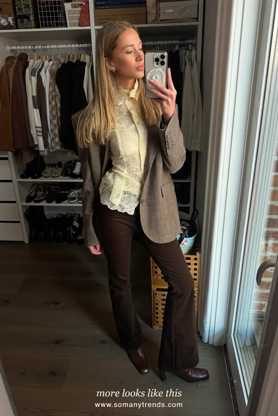Woman in cream lace blouse, brown wool blazer, flared dark pants and brown heeled boots, look 20