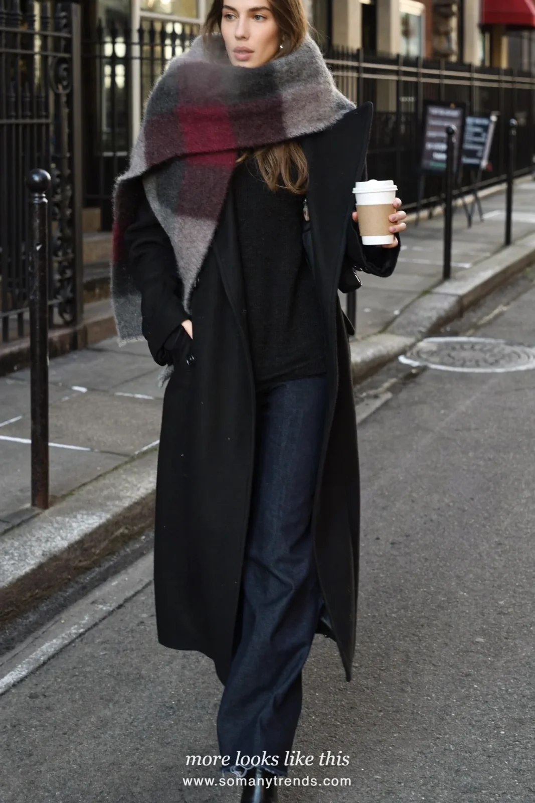 Woman in gray burgundy check wool scarf, black long coat, black knit, dark jeans and black boots, look 26