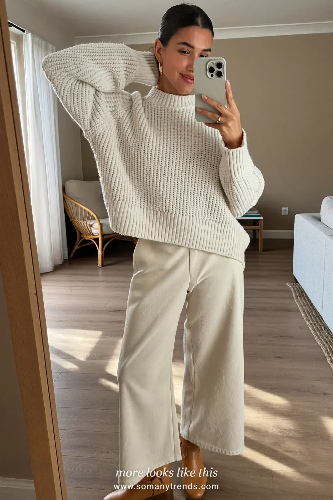Woman in burgundy long wool coat, cream knit, cream pants and tan boots, look 28