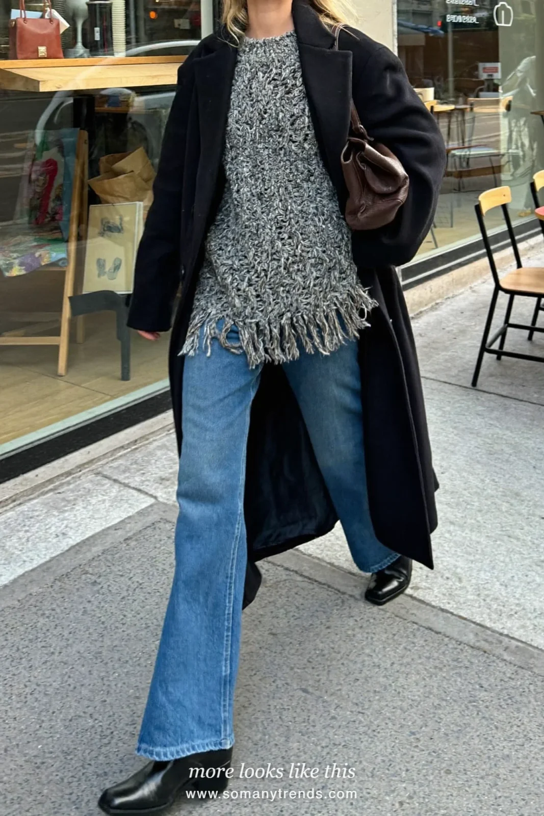 Woman in gray fringe-hem oversized knit, wide-leg blue jeans, black boots and black coat, look 29