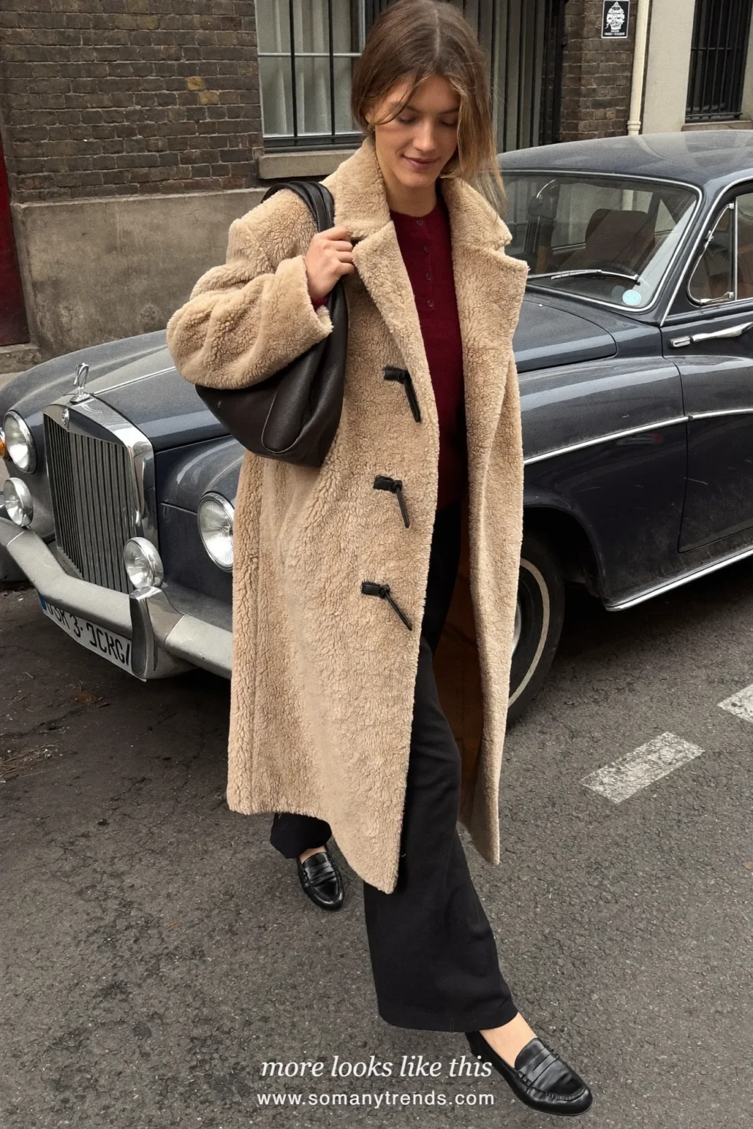 Beige toggle teddy coat over burgundy sweater, black pants and black loafers, outfit 22