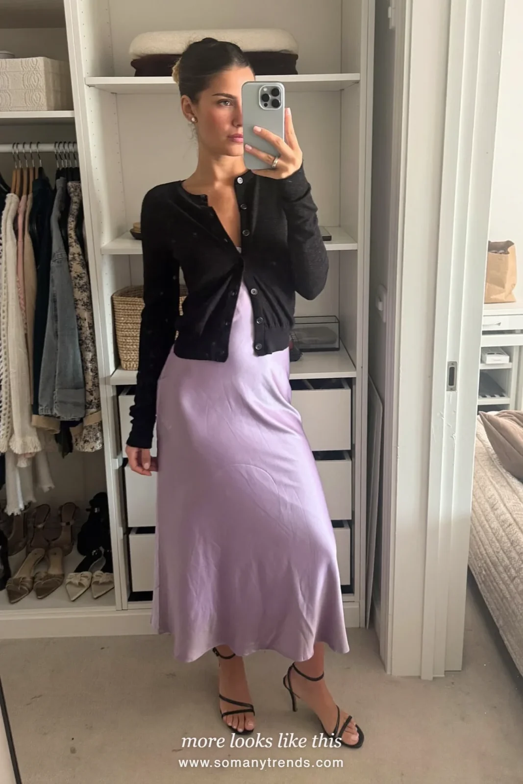 Woman in lilac satin slip dress, black fine-knit cardigan and black heels taking a mirror selfie, outfit 24