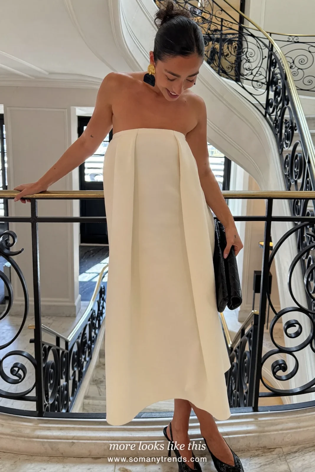 Woman in ivory strapless midi dress, black statement earrings and black slingbacks, outfit 26