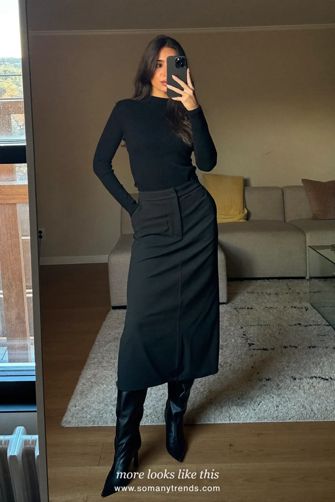 Woman in a mirror selfie at home wearing a black ribbed top, black maxi skirt and black boots, outfit 8