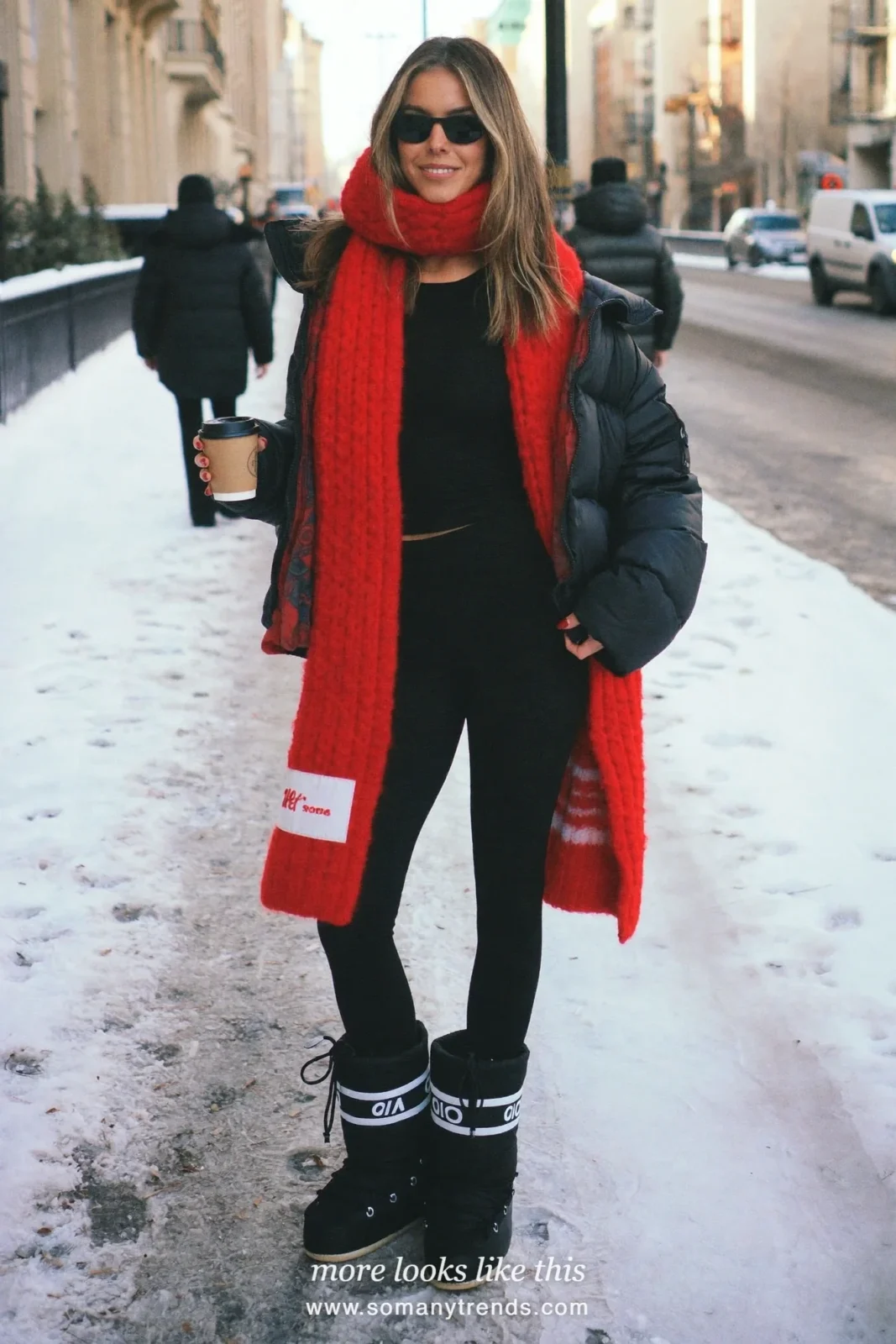 Black puffer with red chunky knit scarf, black leggings and boots on a snowy street, outfit 21