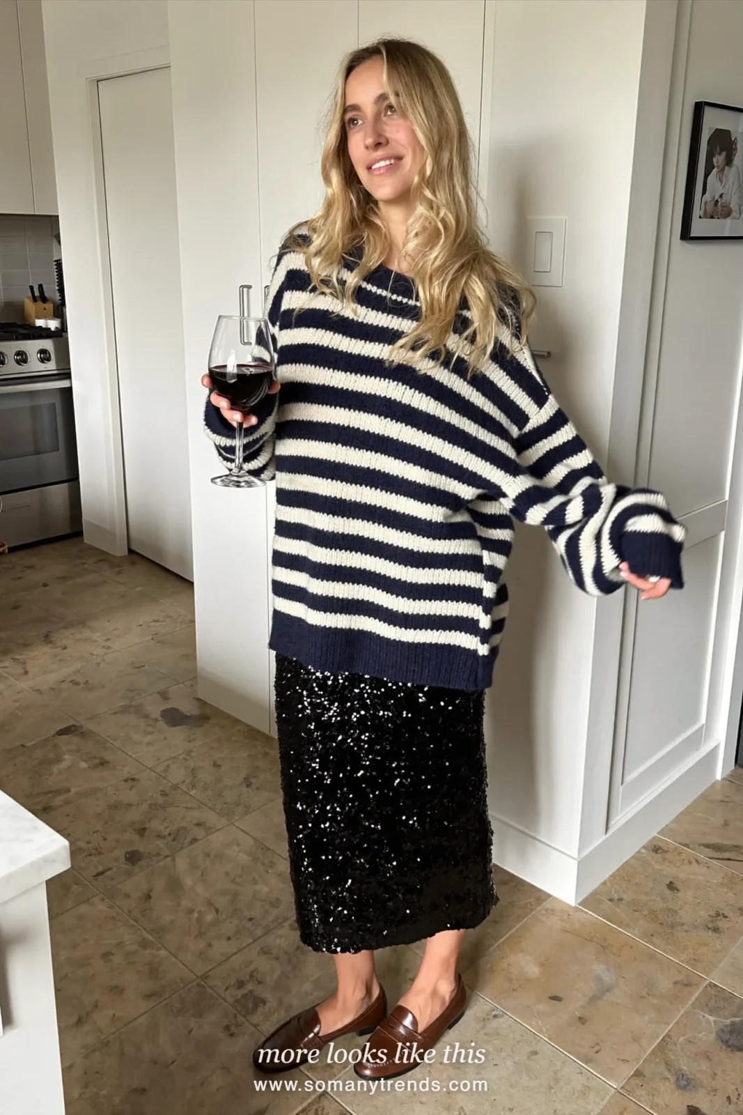 Woman in a navy striped sweater, champagne sequin midi skirt and brown loafers, house party outfit 6