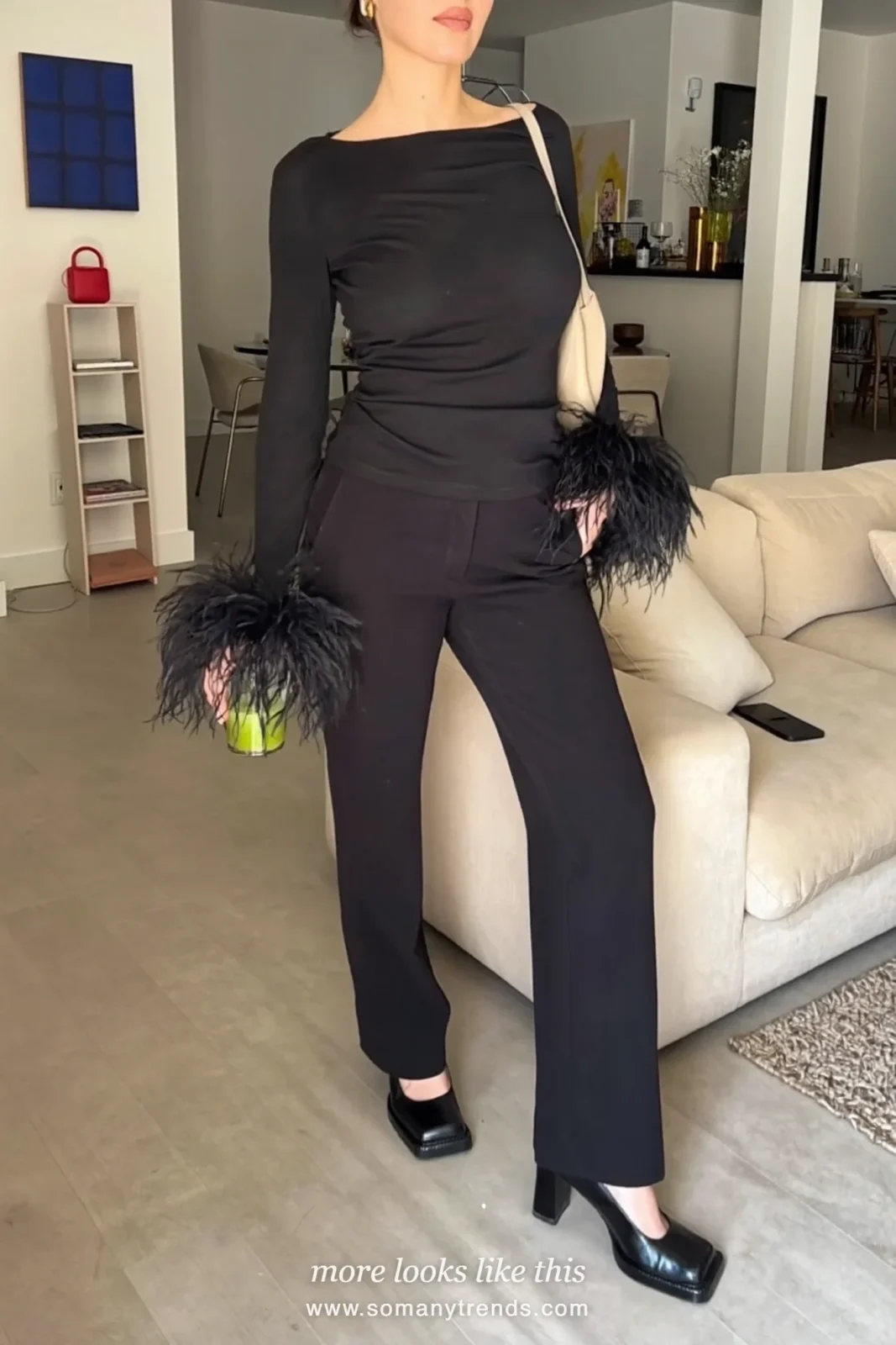 Woman in a black feather-cuff top, black wide-leg pants and block heels, house party outfit 7