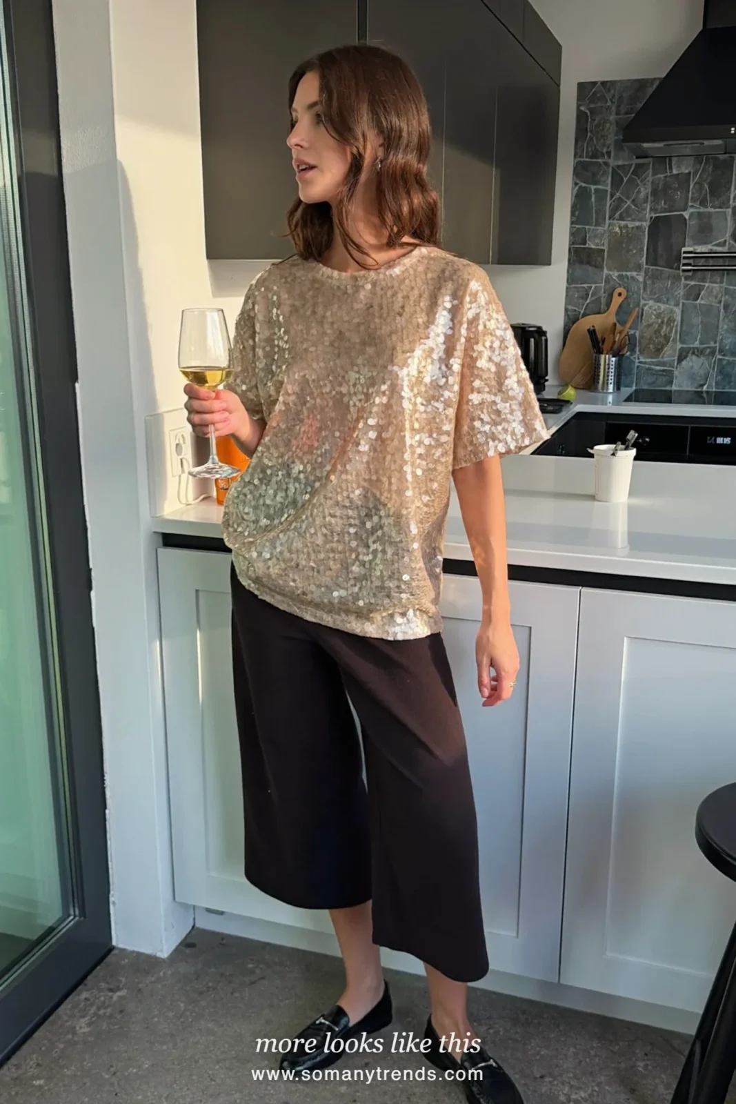 Woman in a champagne sequin tee, black straight pants and black loafers, house party outfit 18