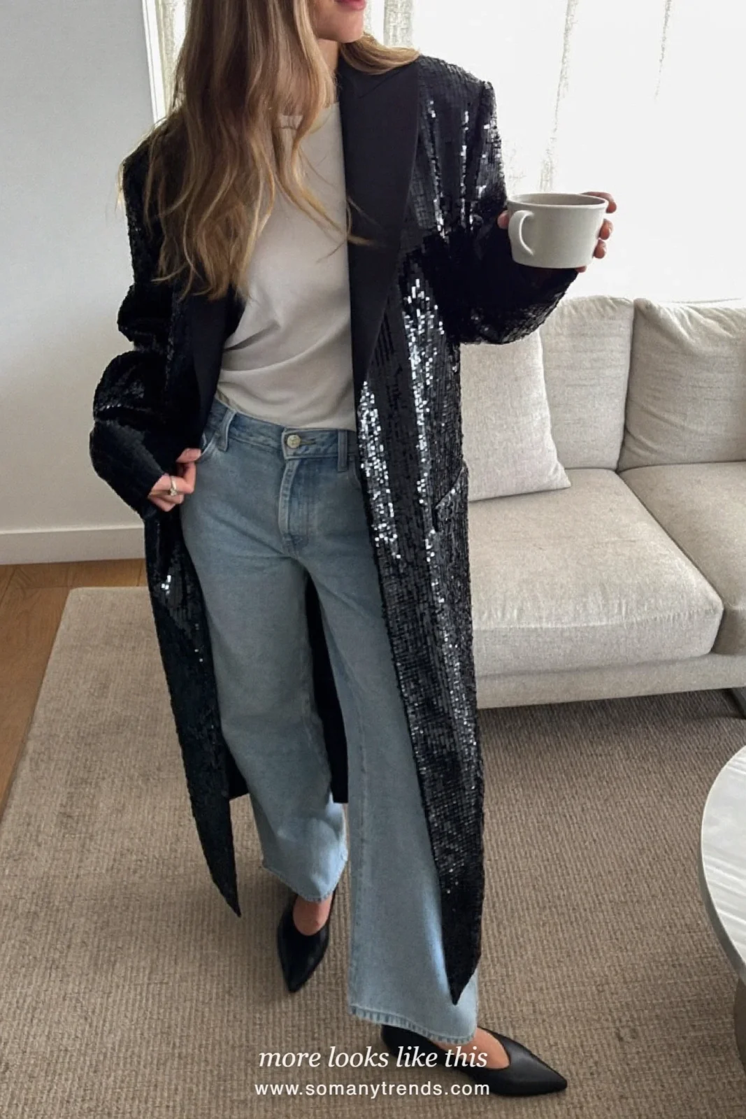 Woman in a black sequin blazer, white tee and wide-leg jeans with flat boots, house party outfit 26