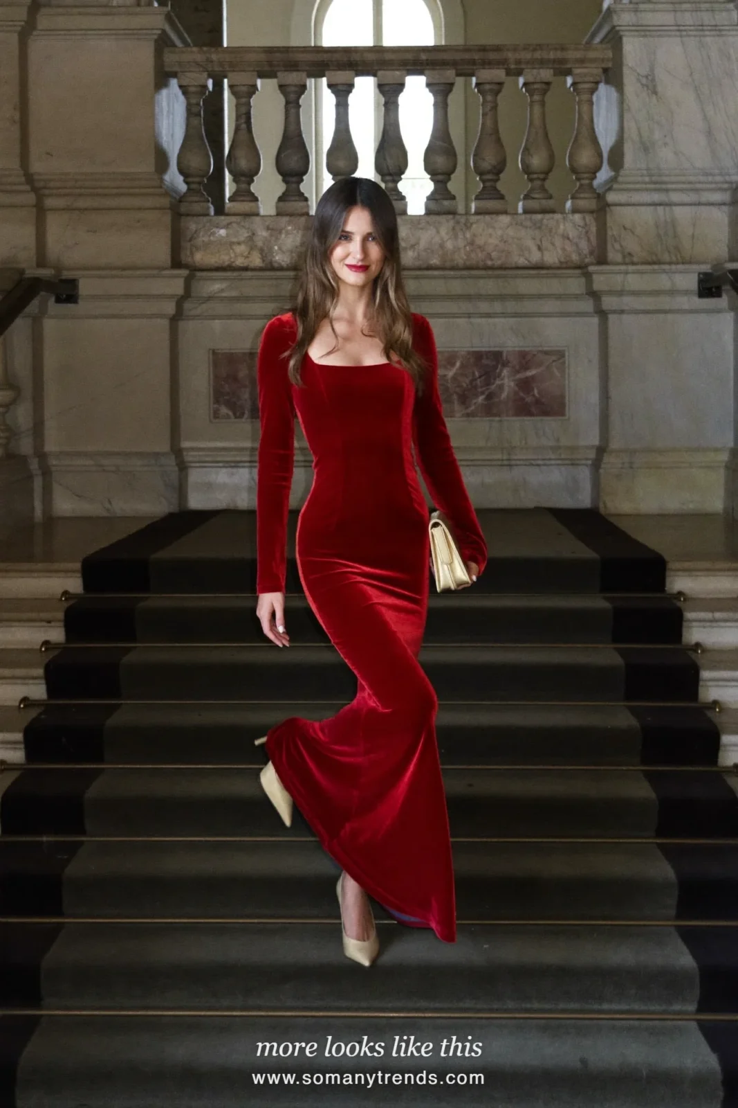 Woman in a red velvet long-sleeve gown on a staircase, outfit 21