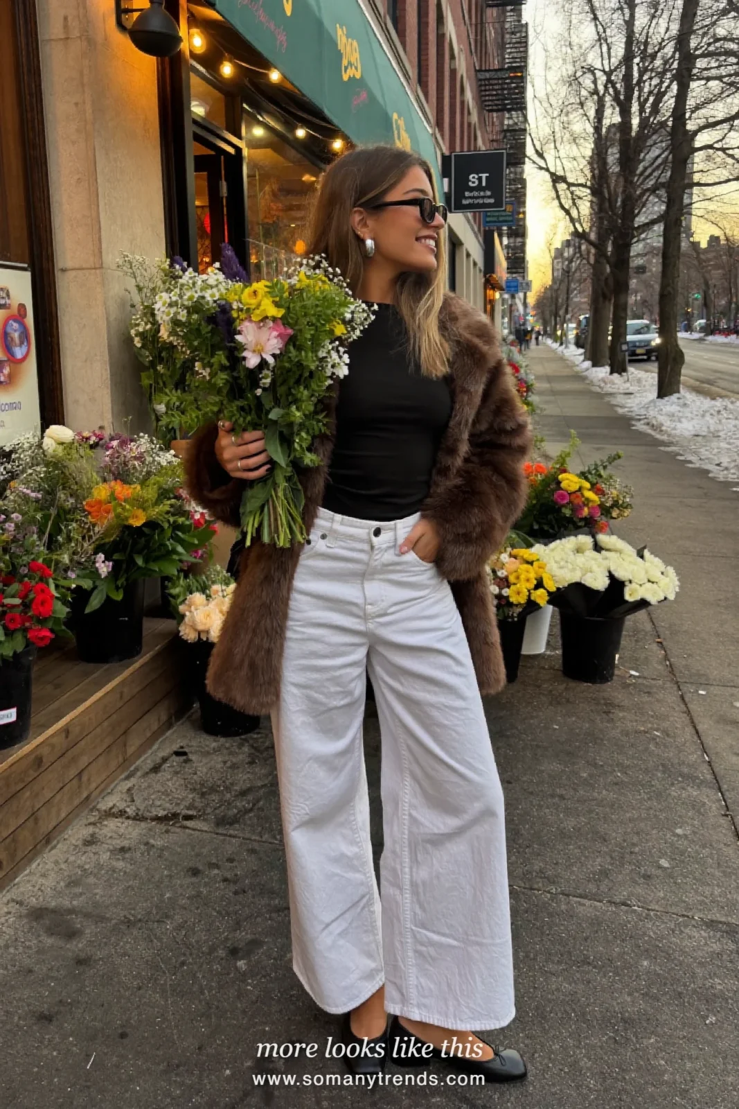 Woman in brown faux-fur jacket, white wide-leg jeans and black flats holding flowers, outfit 2