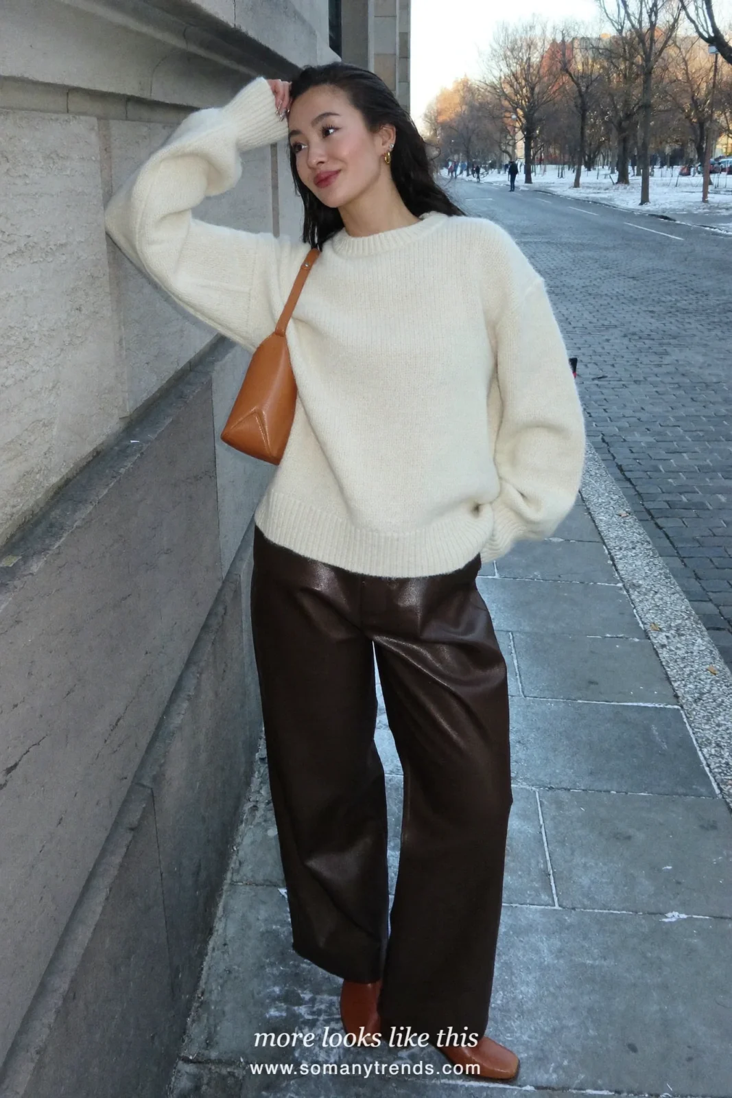 Woman in chocolate brown leather wide-leg pants, cream sweater and tan bag with brown boots, outfit 9