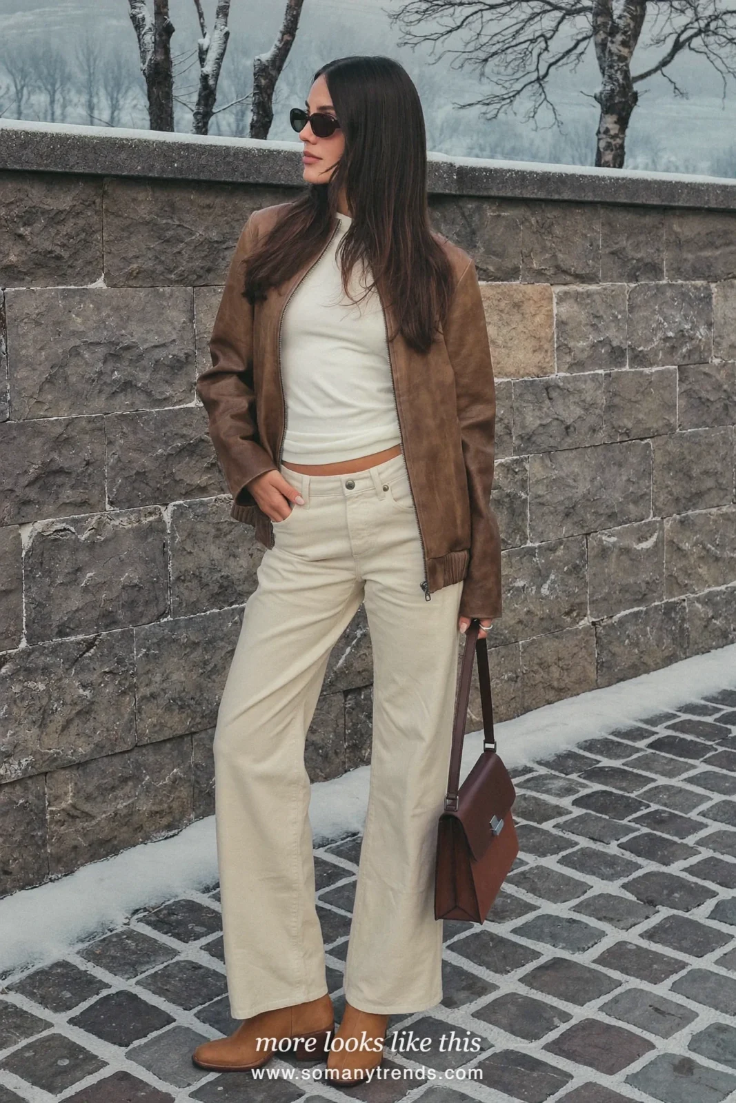 Woman in cream wide-leg pants, brown leather jacket, white tee and tan boots, outfit 17
