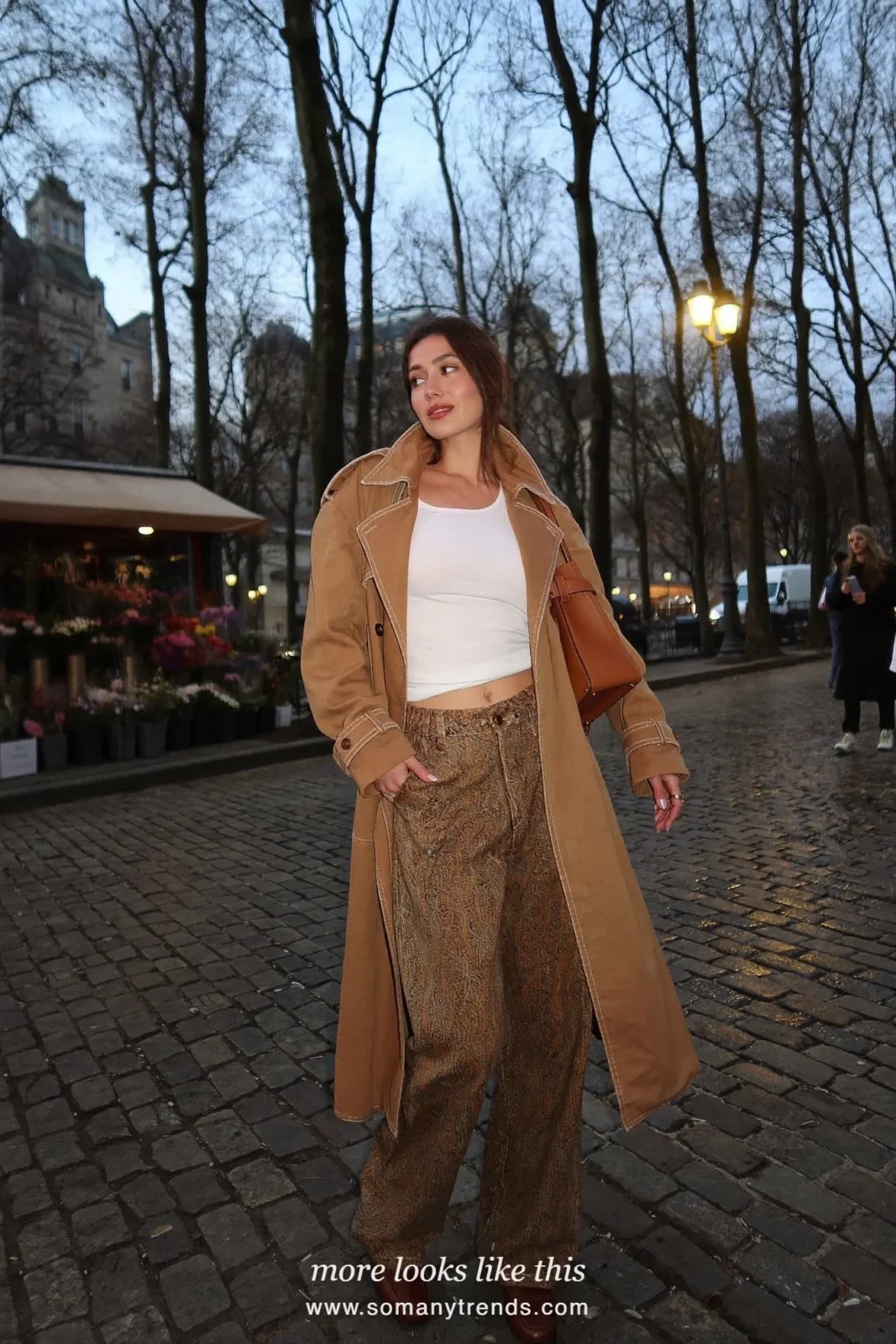 Woman in brown paisley wide-leg pants, camel trench coat, white top and brown loafers, outfit 21