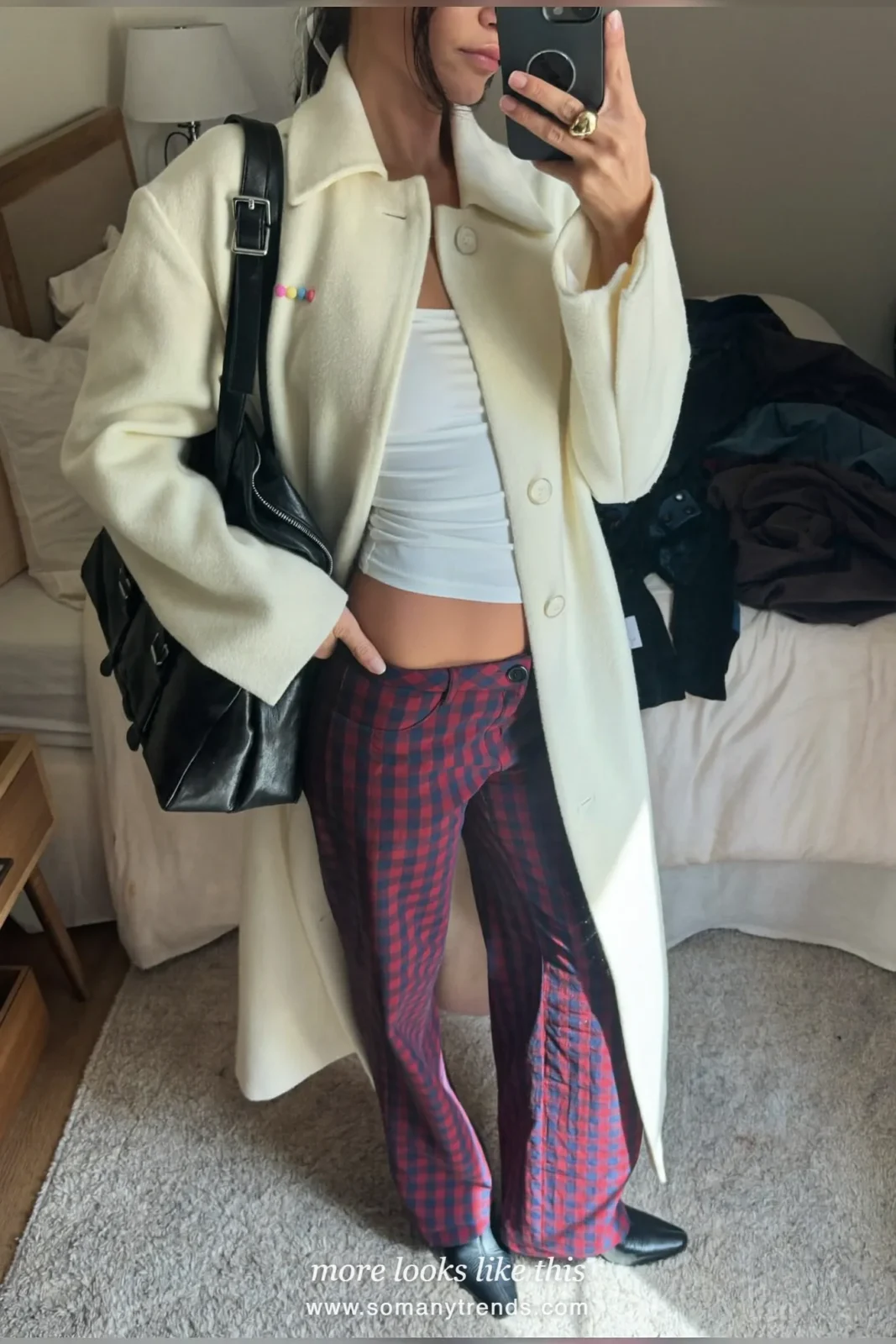 Woman in burgundy and navy check wide-leg pants, cream coat, white knit and black boots, outfit 24