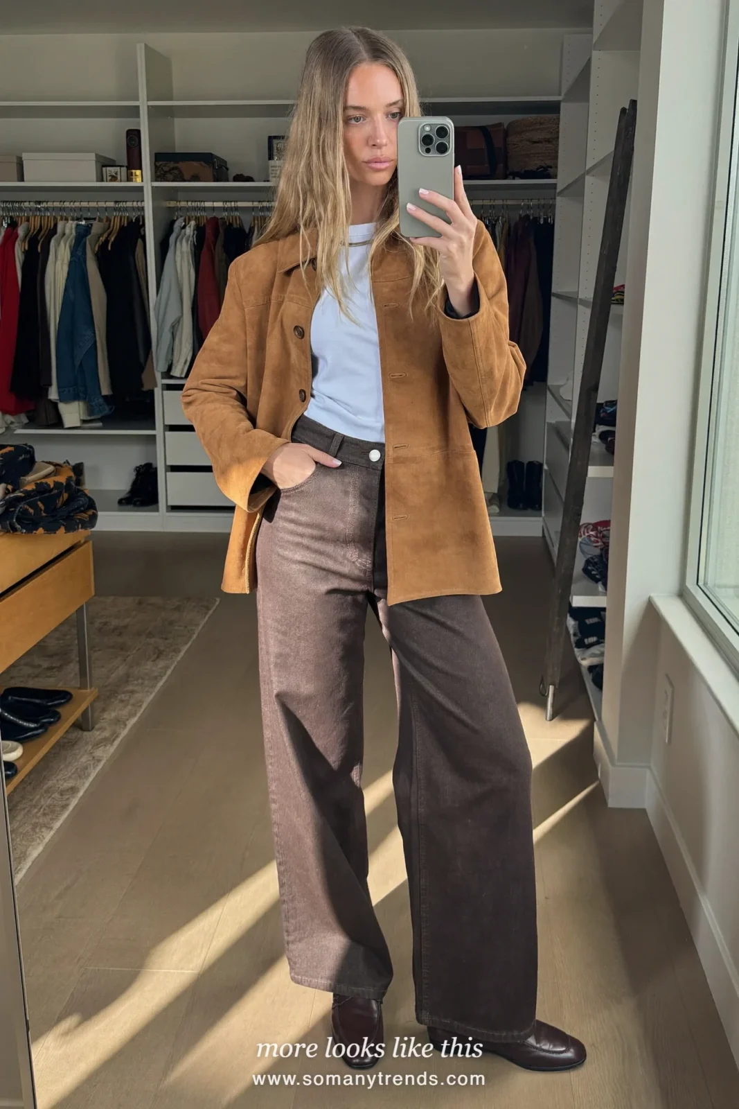 Woman in chocolate brown wide-leg jeans, tan suede jacket, white tee and brown loafers taking a mirror selfie, outfit 28