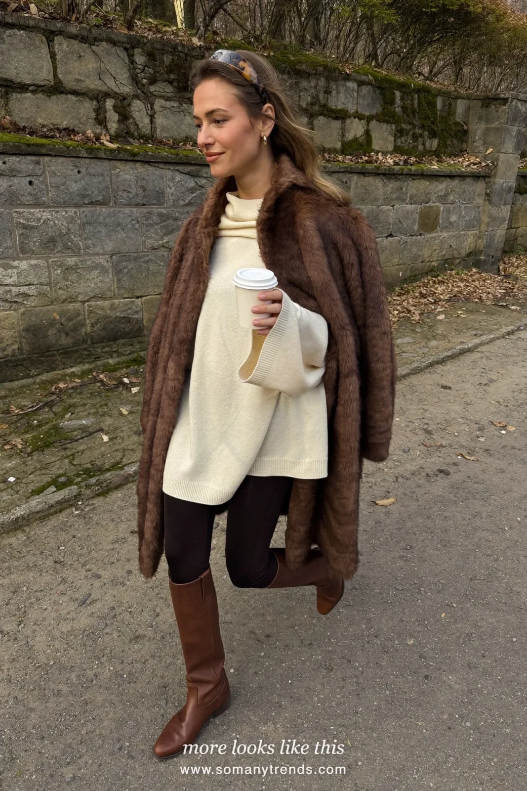 Long chocolate faux fur coat over an oversized cream sweater, black leggings, brown riding boots and a thick headband, outfit 10